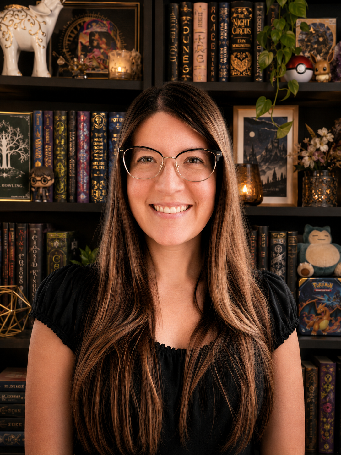 Adalie Jordin — author headshot, smiling in front of a bookshelf filled with fantasy novels